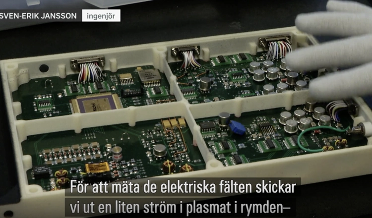 Ingenjören Sven-Erik Jansson pratar i inslaget över en bild av elektroniken i instrumentet, textat "För att mäta de elektriska fälten skickar vi ut en liten ström i plasmat i rymden". Ingenjören Sven-Erik Jansson pratar i inslaget över en bild av elektroniken i instrumentet, textat "För att mäta de elektriska fälten skickar vi ut en liten ström i plasmat i rymden".