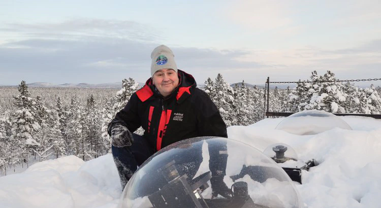 Urban Brändström på observatoriets tak där kameror syns under glaskupoler, med ett vintrigt landskap i bakgrunden.