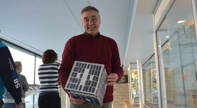 En leende Stas Barabash med en modell av en minisatellit i famnen