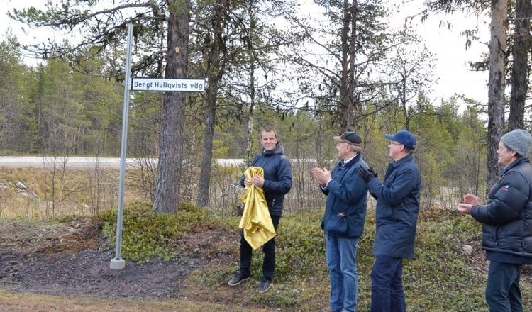 Kommunalrådet Gunnar Selberg avtäcker vägskylten för Bengt Hultqvists väg i sällskap av aplåderande Stas Barabash (IRF), Olle Norberg (LTU) och Craig Heinselman (EISCAT).