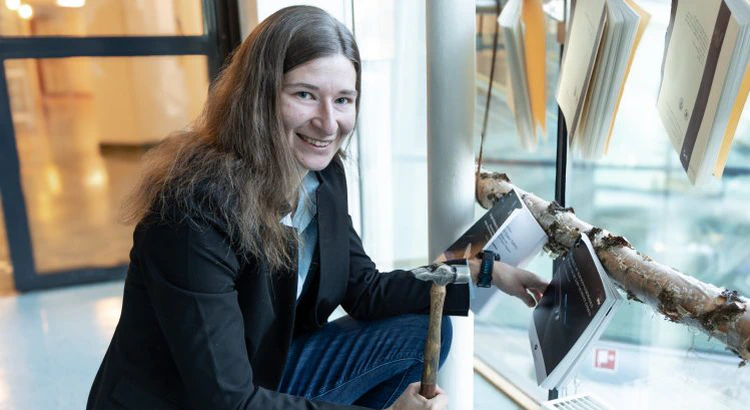 Anja Möslinger med hammare i handen framför sin spikade avhandling Anja Möslinger med hammare i handen framför sin spikade avhandling
