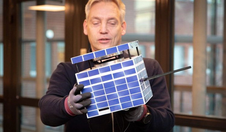 Jonas Olsen med modellen av Munin i famnen