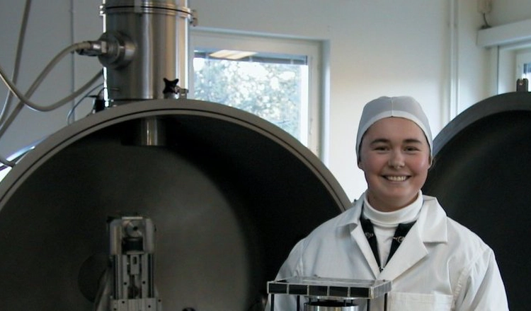 Doktoranden Solveig Høymork med mikrosatelliten Munin i famnen, framför en öppen vakumkammare i IRF:s SpaceLab Doktoranden Solveig Høymork med mikrosatelliten Munin i famnen, framför en öppen vakumkammare i IRF:s SpaceLab
