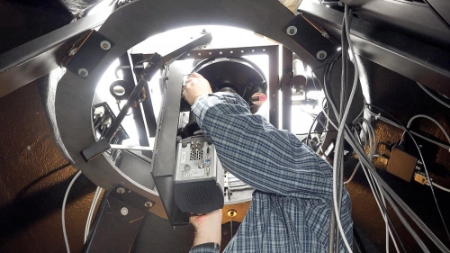 Urban Brändström installing the camera system under the dome inside the station
