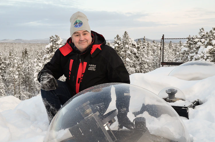 Urban Brändström in winter gear on the snow-covered roof of the observatory