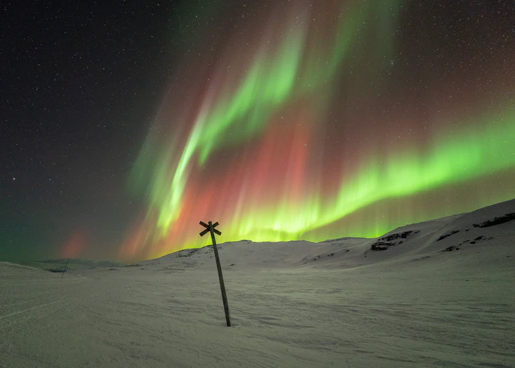 Skoterled med norrsken över himlen