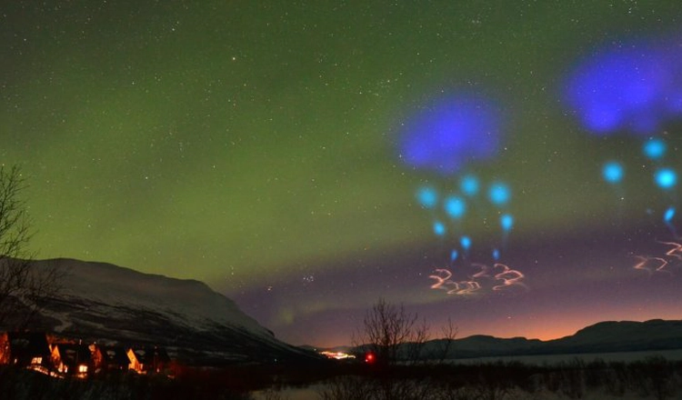 Colorful artificial clouds and regular aurora over mountains