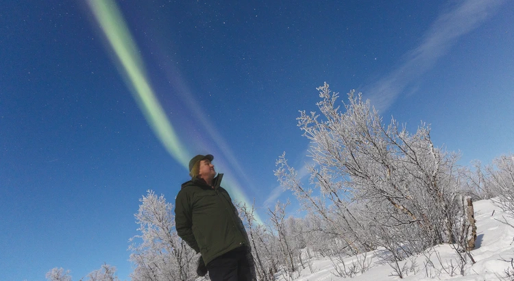 Person under norrskenshimmel